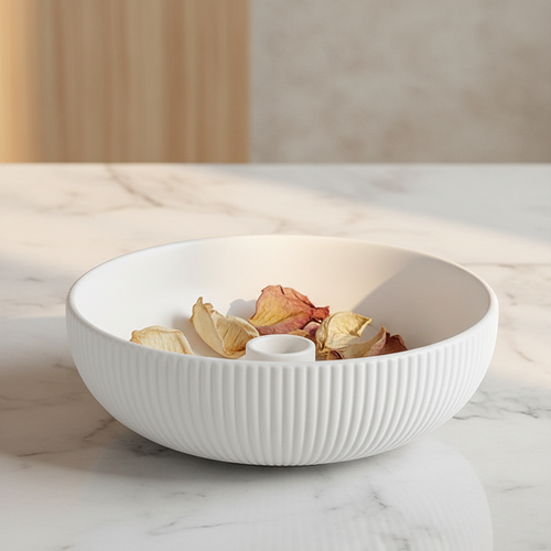 White ribbed ceramic bowl on marble with dried petals